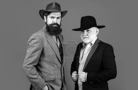Photo for Head shot portrait of elderly mature senior dad and grownup son. Two male generations family. Men in hat. Men in different ages in studio - Royalty Free Image