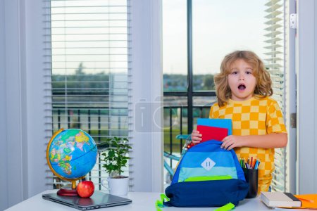 Photo for Child from elementary school with book doing homework at home. Little student, clever nerd pupil ready to study. First time to school. Concept of education and learning - Royalty Free Image