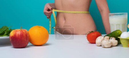Photo for Weight loss. Woman measure waistline with weight loss.. Calories and fruit diet concept. Vegetarian fresh food for weight loss. Close up belly stomach. Healthy metabolism. Fit perfect figure, weight - Royalty Free Image