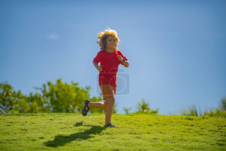Photo for Cute boy running on green grass and blue sky. Healthy sport activity and running for children. Little boy at race. Young athlete in training. Runner exercising. Jogging for kid - Royalty Free Image