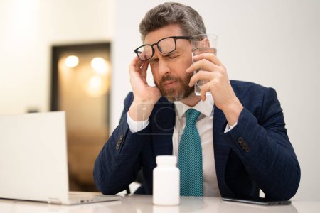 Photo for Tired man having a terrible headache. Exhausted man feeling unhealthy, upset about headache illness. Stressed middle-aged man having headache. Migraine and headache concept - Royalty Free Image