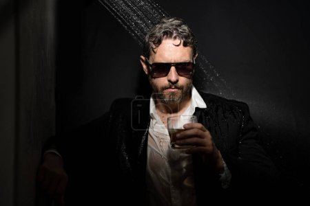 Photo for Personality crisis, midlife crisis. Middle age crisis. Sad business man in suit drinking whisky under shower in bath. Business crisis. Middle-aged gray hair feeling depressed. Alcohol and drugs addict - Royalty Free Image