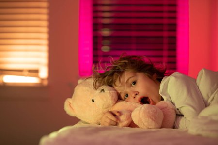 Photo for Scared boy in bed. Drowsy kid in bed with comfortable mattress soft pillow white bedding. Child is afraid of the dark. Nightmares and terrible dreams in children - Royalty Free Image
