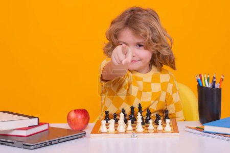 Photo for Portrait of cute child play chess on studio isolated background. Kid playing chess. Clever child thinking about chess. Kids early development - Royalty Free Image