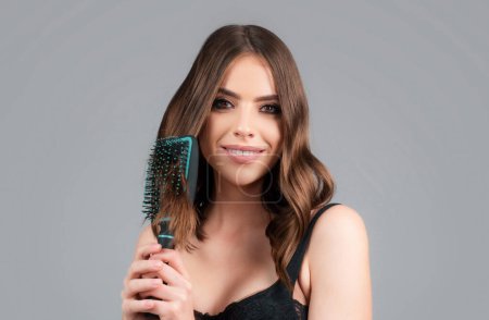 Photo for Young beautiful woman combing brown hair. Hair Care. Beautiful brunette woman hairbrushing hair with hairbrush. Brushing healthy hair with comb - Royalty Free Image