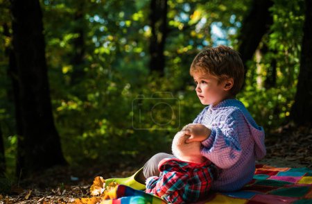 Téléchargez les photos : Garçon mignon avec feuilles d'automne sur fond nature automne
. - en image libre de droit