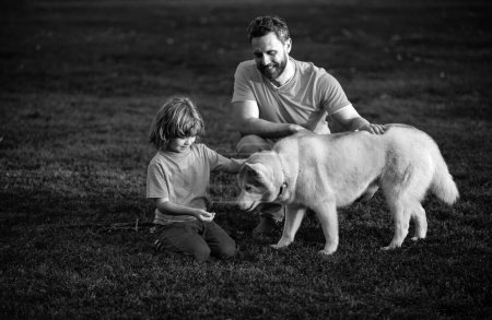 Foto de Padre e hijo con perro mascota pasar tiempo al aire libre juntos - Imagen libre de derechos