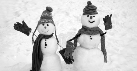 Téléchargez les photos : Bonhomme de neige en chapeau et écharpe sur terrain enneigé. Joyeux Noël et bonne année carte de vœux avec espace de copie - en image libre de droit