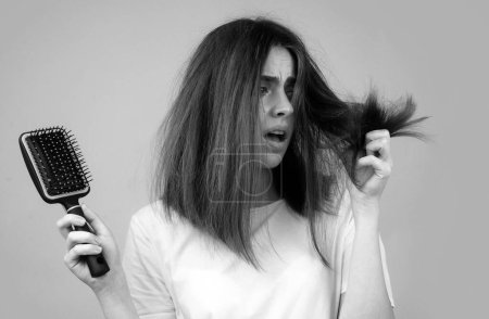 Foto de Chica triste mirando el cabello dañado, el problema de la pérdida de cabello. Espacio aislado, copia - Imagen libre de derechos