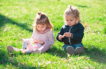 Photo for Cute boy and girl on summer field. Cute babys sit on green grass in summertime. Funny little kid on nature. Happy Childhood - Royalty Free Image