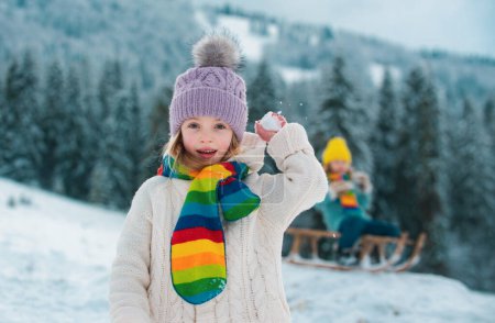 Photo for Two little kids have fun with snowball fight in the beautiful winter nature. Winter knitted clothes for children - Royalty Free Image