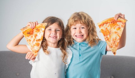 Photo for Children eating pizza. Happy excited children eating pizza and having fun together. Happy kids holding pizza slice near face - Royalty Free Image