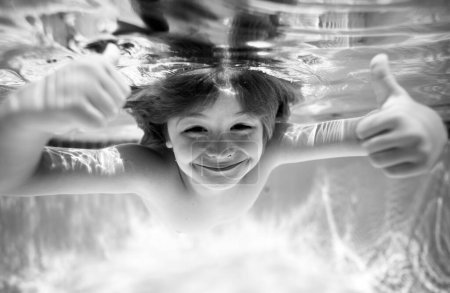 Téléchargez les photos : Les enfants excités drôles font face sous l'eau. Enfant dans la piscine le jour d'été. Enfant sous-marin nage dans la piscine, enfant sain nageant et s'amusant sous l'eau - en image libre de droit
