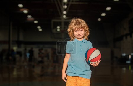 Téléchargez les photos : Un gamin qui joue au basket. Joueur de basket-ball enfant à l'école - en image libre de droit