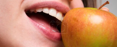 Téléchargez les photos : Belle jeune femme mangeant de la pomme rouge. Mordre une pomme. Bouche fermer - en image libre de droit