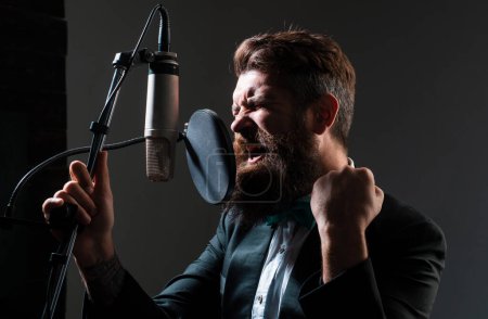 Téléchargez les photos : Singer singing rock. Sound producer recording song in a music studio. Excited Singer gestures with hands - en image libre de droit
