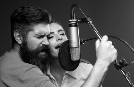 Téléchargez les photos : Couple chanteur de karaoké. Homme et femme chantant avec microphone de musique - en image libre de droit