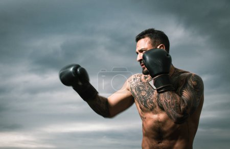 Foto de Boxeador practicando golpes en el boxeo. Boxeador golpeando en guantes de boxeo. Hombre deportivo durante el ejercicio de boxeo. Fuerza y motivación. Golpe de boxeador - Imagen libre de derechos