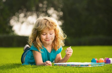 Téléchargez les photos : Enfants créatifs, développant l'imagination, la créativité. Peinture pour enfants avec des peintures couleur et pinceau dans le parc extérieur - en image libre de droit