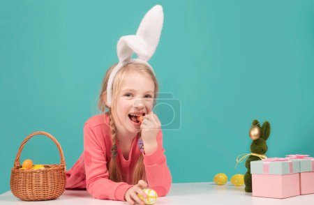 Photo for Easter kid girl in bunny costume isolated on blue studio background - Royalty Free Image