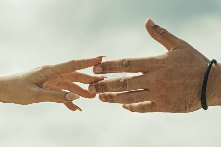 Foto de Un par de manos con tatuaje. Ayudando a la mano. Tomando la mano, de cerca. Echando una mano. Rescate, ayuda gesto o manos. Relaciones de salvación. Ayuda gesto o manos. Mano de apoyo - Imagen libre de derechos