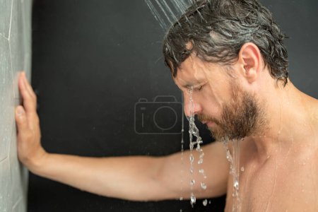 Foto de Hombre lavando el pelo, cerrando el retrato. Hombre ducha de baño lavando cabezal de pelo en el baño. Modelo masculino lavando el cabello en la ducha. Hombre sexy duchándose. Un tipo duchándose. Champú masculino y concepto de lavado del cabello - Imagen libre de derechos