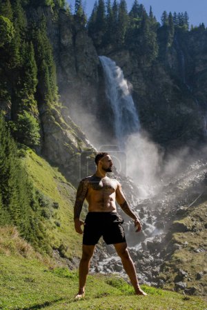 Photo for Man in Alps waterfall. Sexy man. Man freedom lifestyle. Meditating in nature. Hispanic man practicing yoga. Lifestyle relaxation concept, summer meditation on nature. Calmness and relax in nature - Royalty Free Image