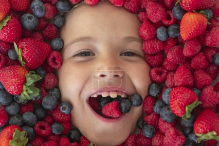 Photo for Fruits for kids. Kids face with berries strawberry, blueberry, raspberry, blackberry - Royalty Free Image