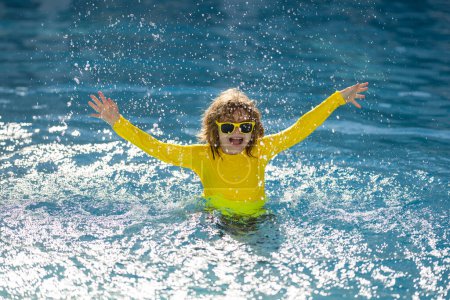 Téléchargez les photos : Enfant profitant de vacances d'été, nageant dans la piscine. Le gamin s'amuse pendant les vacances d'été à la piscine. Des enfants heureux jouant sur l'eau de la piscine. Enfants heureux en vacances d'été jouer dans l'eau dans la piscine - en image libre de droit