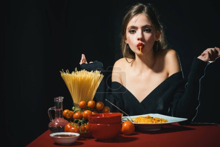 Téléchargez les photos : Femme sexy mangeant des spaghettis aux pâtes italiennes. Faim, appétit et recette. Délicieux spaghettis. Cuisine italienne. L'amour spaghetti. Une femme sensuelle mange des spaghettis. Une fille affamée. Pâtes dans la bouche - en image libre de droit
