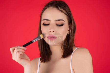 Photo for Woman applying foundation powder or blush with makeup brush. Facial treatment, perfect skin, natural make up, facial beauty. Isolated on studio background. Applying makeup - Royalty Free Image