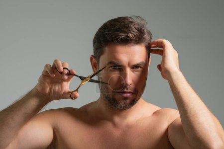 Photo for Mens hairstyle, haircut. Middle aged man with scissors cut hair. Mens haircare, beauty barber concept. Bearded man, with scissors. Cut hair with scissors. Man hair styling and cut hair with scissors - Royalty Free Image