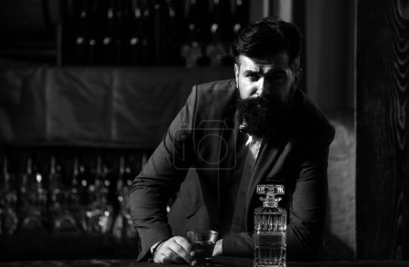 Photo for Barman luxury beverage concept. Man with beard holds glass with alcohol in bar. Waiter bartender in vintage vest with whiskey or scotch on tray - Royalty Free Image