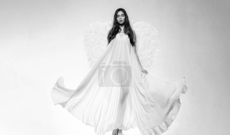 Foto de Concepto de San Valentín y vestuario. Mujer joven disfrazada de ángel. Ángel con regalo. Ángel blanco caído. Hermosa mujer posando con alas de ángel - Imagen libre de derechos