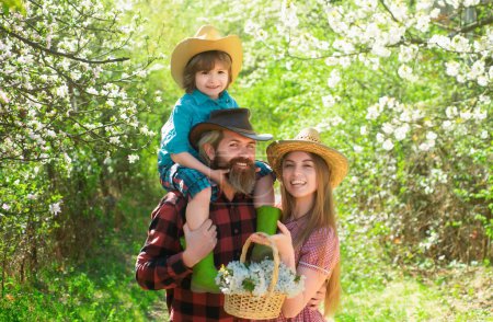 Photo for Cheerful family on picnic in a park. Family Farmers working in tree garden at spring. Father mother and child work in yard with gardener tools - Royalty Free Image