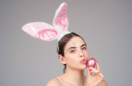 Foto de Conejita con huevo de Pascua. Chica conejo con huevo de color. Mujer con orejas de conejo. Caza de huevos - Imagen libre de derechos
