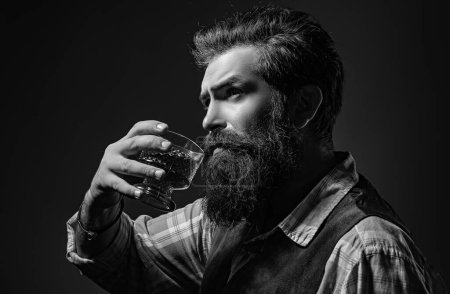 Foto de Hombre camarero con barba sostiene brandy de vidrio. Sommelier sabe bebida alcohólica cara - Imagen libre de derechos