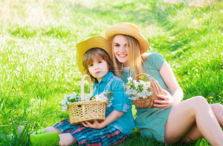 Téléchargez les photos : Famille de jardiniers joyeux assis lors d'un pique-nique dans le jardin. Jeune famille souriante se détendre au soleil jour. - en image libre de droit