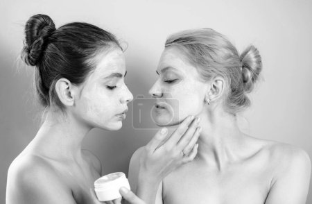 Téléchargez les photos : Deux belles femelles en bonne santé avec masque facial prennent soin l'une de l'autre. Motivation santé et beauté. Concept de procédures Spa. Cosmétique bio naturelle pour une peau jeune et lisse - en image libre de droit