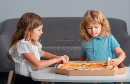 Foto de Niños hambrientos comiendo pizza. Niños preparándose para comer pizza fresca - Imagen libre de derechos