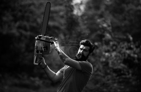Photo for Deforestation is a major cause of land degradation and destabilization of natural ecosystems. A handsome young man with a beard carries a tree - Royalty Free Image