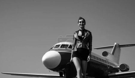 Photo for Stewardess and travel time. Portrait of smiling flight attendant serving on airplane background. Flight attendant uniform. Plane travel. Woman stewardess. Copy spase, isolated on blue - Royalty Free Image