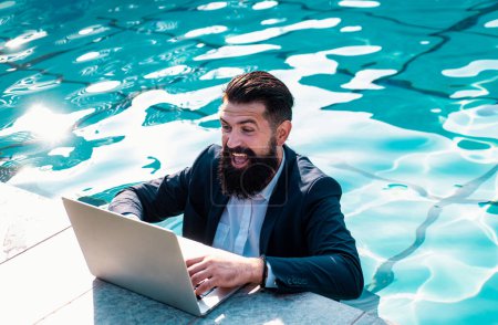 Téléchargez les photos : Homme d'affaires excité en costume avec ordinateur portable dans la piscine. Homme d'affaires drôle, concept d'entreprise comique fou - en image libre de droit