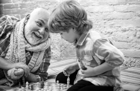 Téléchargez les photos : La compétition d'échecs. Joli garçon développant une stratégie d'échecs. Grand-père et petit-fils jouant aux échecs. Concept de grand-père et petit-fils - en image libre de droit