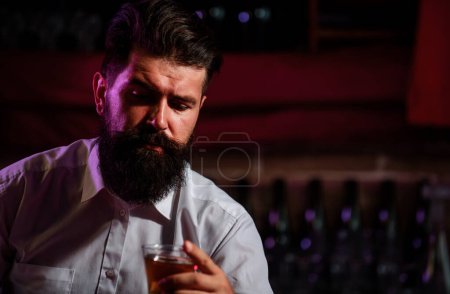 Photo for Close up of a stylish handsome bearded man enjoying a brandy or whiskey - Royalty Free Image