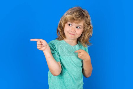 Photo for Child pointing away on isolated studio background. Kid with index finger pointing, copyspace - Royalty Free Image