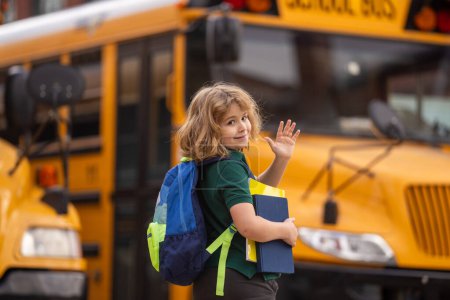Foto de Alumno con mochila y libro subiendo al autobús escolar. Escuela Americana. De vuelta a la escuela. Adiós, adiós. Niño de la escuela primaria. Niños felices listos para estudiar - Imagen libre de derechos