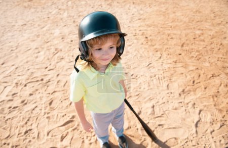 Téléchargez les photos : Batteur enfant drôle sur le point de frapper un terrain pendant un match de baseball. Le base-ball prêt à battre. Visage enfant amusant - en image libre de droit