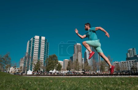 Photo for Full length of healthy man running and sprinting outdoors near city skyline. Male urban runner. Dynamic jump movement - Royalty Free Image