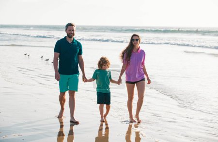 Téléchargez les photos : Famille marchant vers la plage par une journée ensoleillée - en image libre de droit